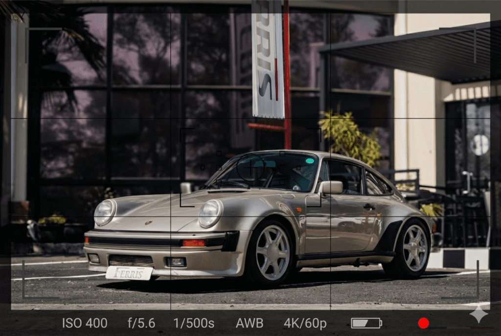 Professional automotive photography of a classic Porsche parked outside a modern building